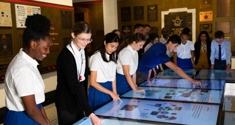 Group of students interacting with touch screens at Anzac Square Memorial Galleries