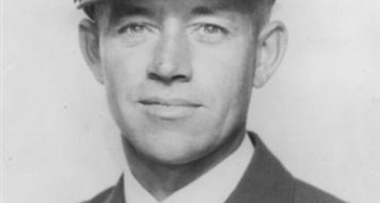 A studio portrait of Charles Rowland Williams taken on completion of his RAAF training in Australia. He is wearing an officer's cap and badge and the AG half wing of a qualified gunner.