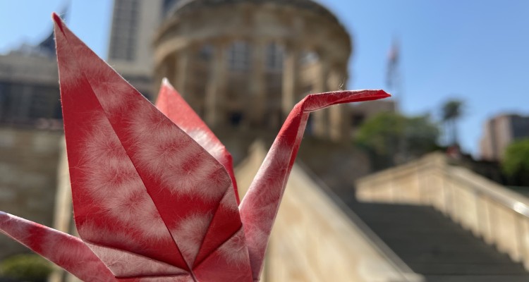 A paper crane in front of the Shrine of Remembrance