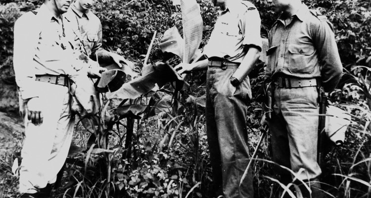 Old photograph of 4 male soldiers standing in a group outside.