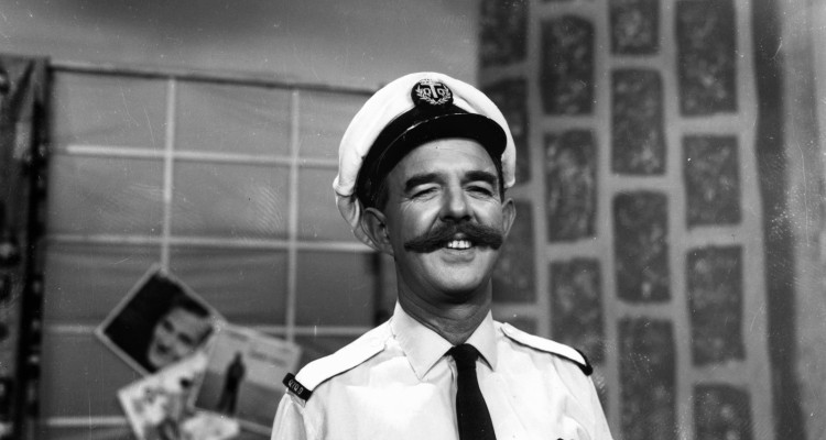man with moustache and naval costume poses for camera