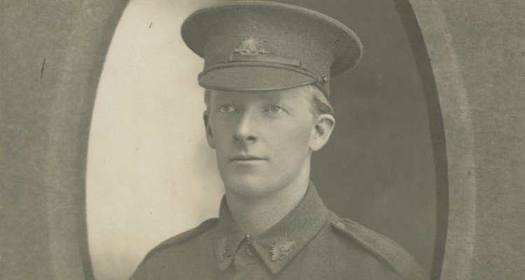 Black and white studio portrait of man in uniform, ca.1916