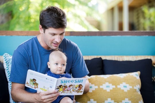 Father reading 'Shoosh!' by Simon Howe to baby