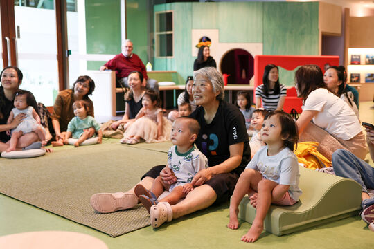 Children and guardians sitting together in The Corner.