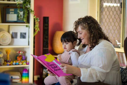 Woman and toddler share a book at home 