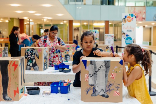 Girls drawing on a box