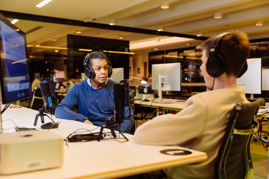 A photo of two men with microphones interviewing each other