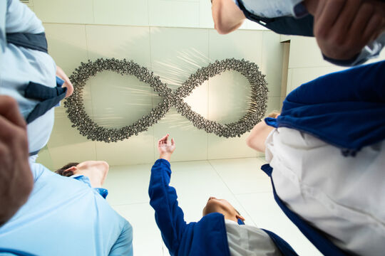 Students looking up at Black Opium by Fiona Foley