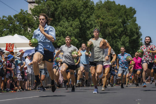 men racing while carrying watermelons