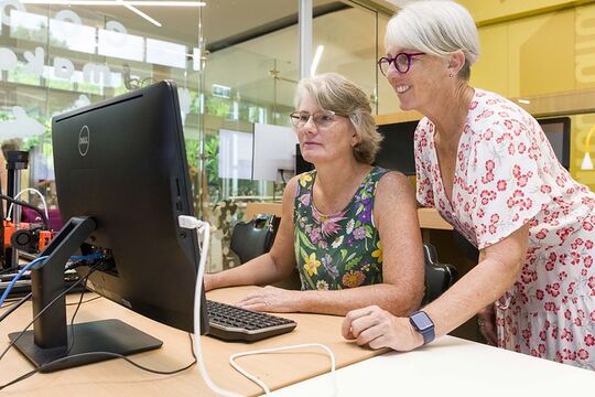Cricut craft activity two women working on a computer at at Corooy Library