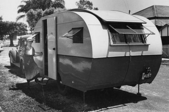 Woman with hat stepping up into a caravan
