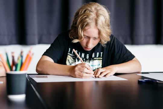 Teen boy writing