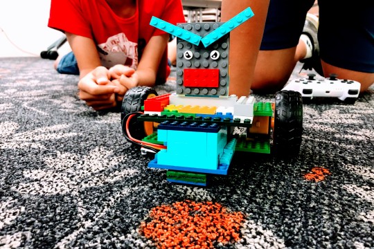 Young people with a custom built Lego robot.