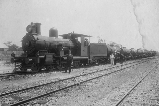 Known as a Juice train this photo shows a loco and workers standing alongside tracks at Isis Station