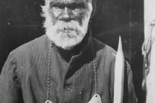 Mickey Woonoo portrait, with King plate around his neck and holding a spear and boomerang. Inscribed on King plate Mickey Woonoo - Narkool - Dalleburra.