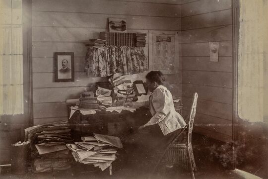 Wilhemina Rawson sitting at desk writing
