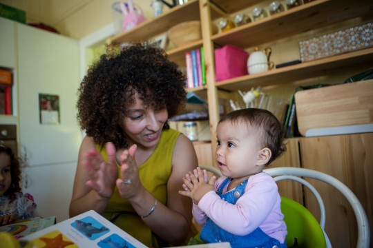 Woman and child using sign language to read a book
