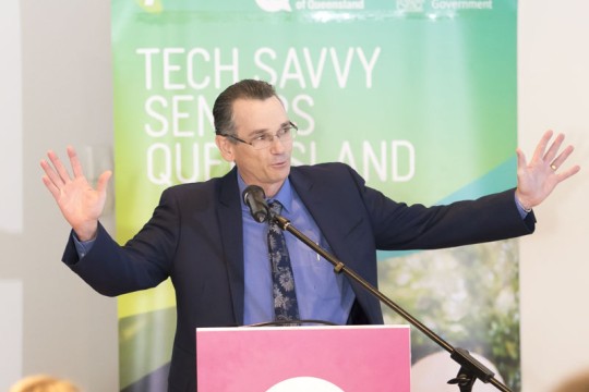A man at a podium speaks about the partnership between State Library and Telstra