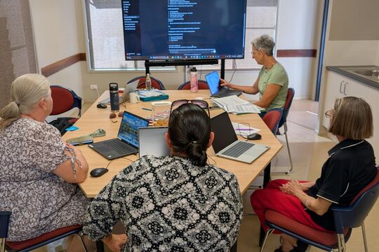 People using computers in digital skills workshop