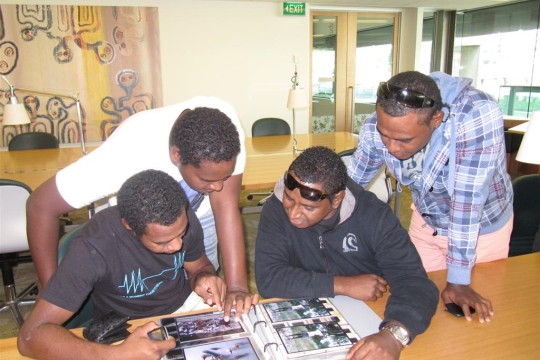 A group of Torres Strait Islander males view images during their visit to the John Oxley Library and exhibition in 2011