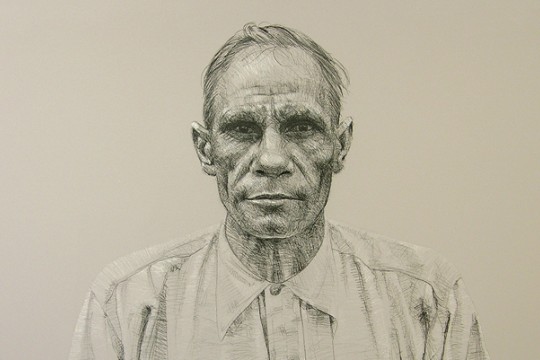 A charcoal portrait of a First Nations man wearing a button up shirt looking at the viewer