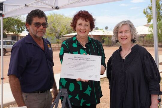 Cr Richard Sewter, Mayor of Mornington Shire Council, The Honourable Fiona Simpson MP, and Vicki McDonald State Librarian and CEO State Library of Queensland, hold up a plaque marking the opening of the Mornington Island digital IKC 