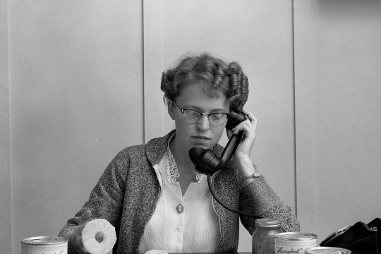 woman sits at a desk surrounded by cans of jam and ginger 