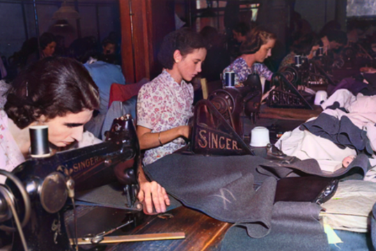 A group of women using Singer sewing machines
