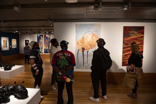 Group of people looking at artworks in exhibition