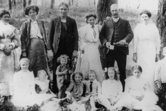 Family posing for photo in a park