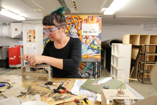 Woman working with cardboard in the Fabrication Lab.