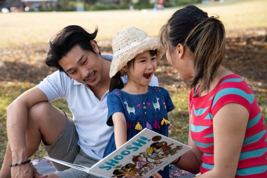 Family reading Shoosh! in the park