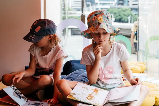 Two girls reading books, Summer Reading Club.