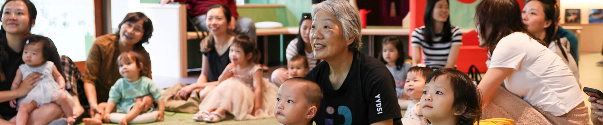 Children and guardians sitting together in The Corner.