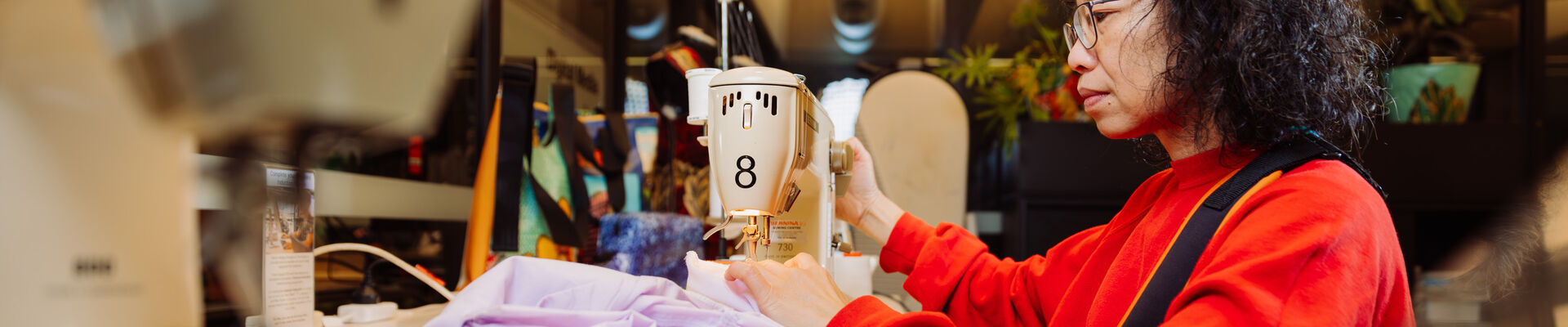 A member of the public using a sewing machine at The Edge