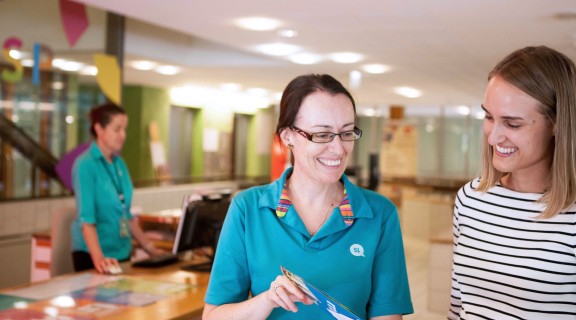Client speaking to reception staff at the State Library of Queensland.