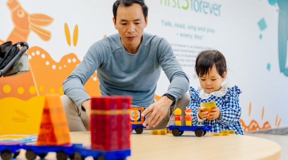 Adult and child play with magnetic blocks