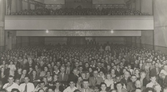 Black and white photo of an audience watching a movie