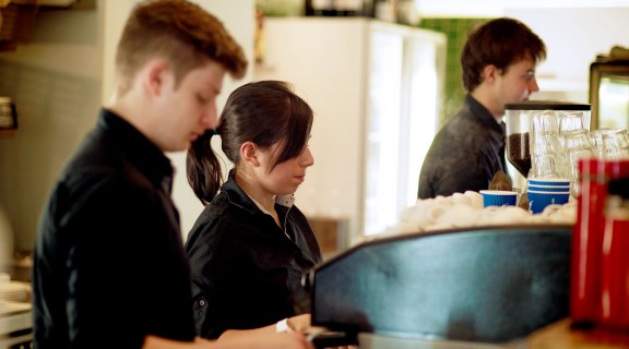 Three staff members working behind the counter in the Library Cafe.