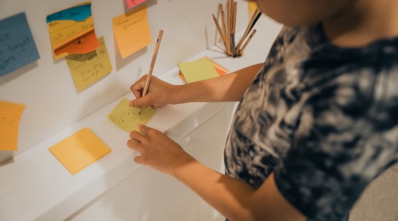 Child writing post-it note at Anzac Square Memorial Galleries