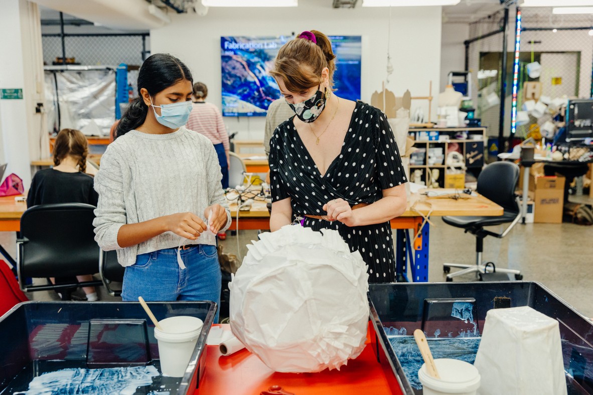 Woman and girl crafting paper sculptures together