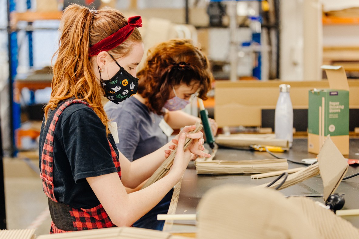 Two girls crafting with cardboard