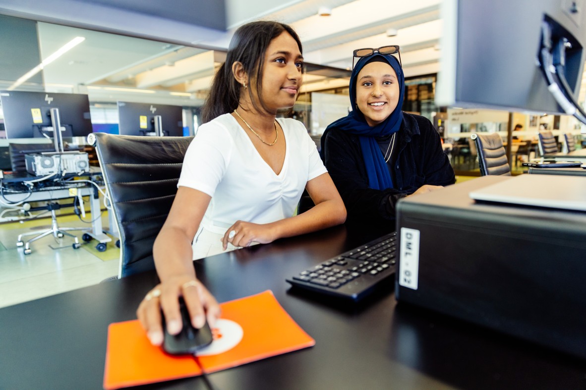 Two young people at a DML computer at The Edge