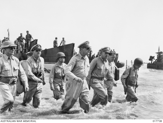 General MacArthur wading through the water from the landing craft to return to the Philippines. He is accompanied by his Chief of Staff, Lieutenant General Sutherland and high ranking officers. President Sergio Osmena is on the extreme left. Francisco Salveron, General MacArthur's aide de camp, is on the far right.