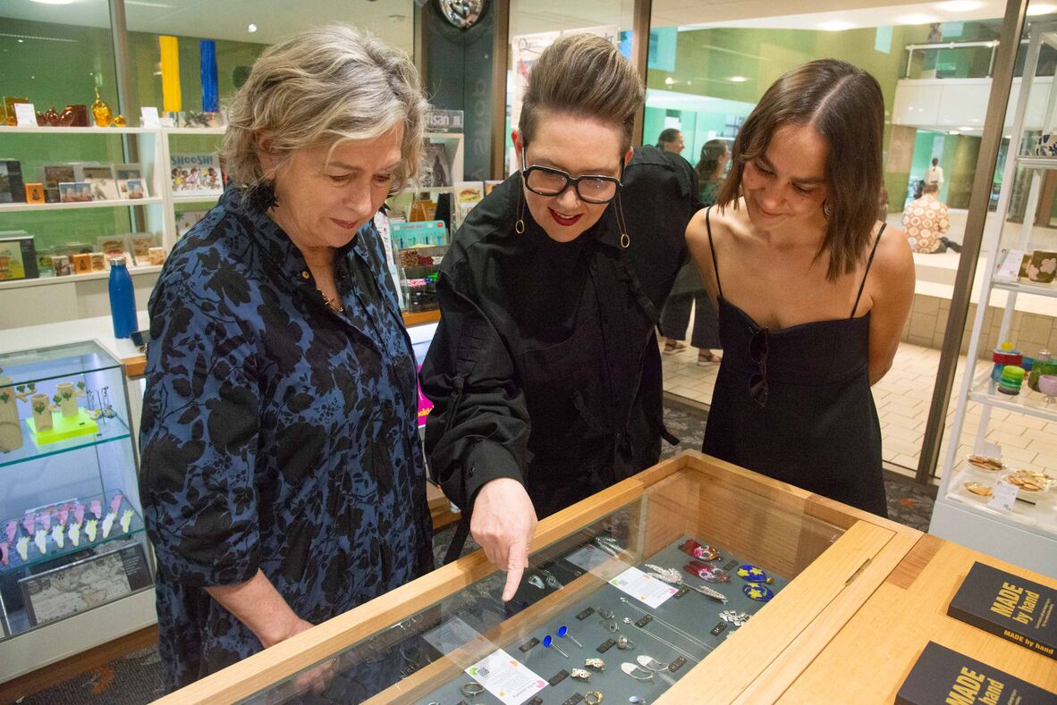 3 women looking at jewellery on display in cabinet