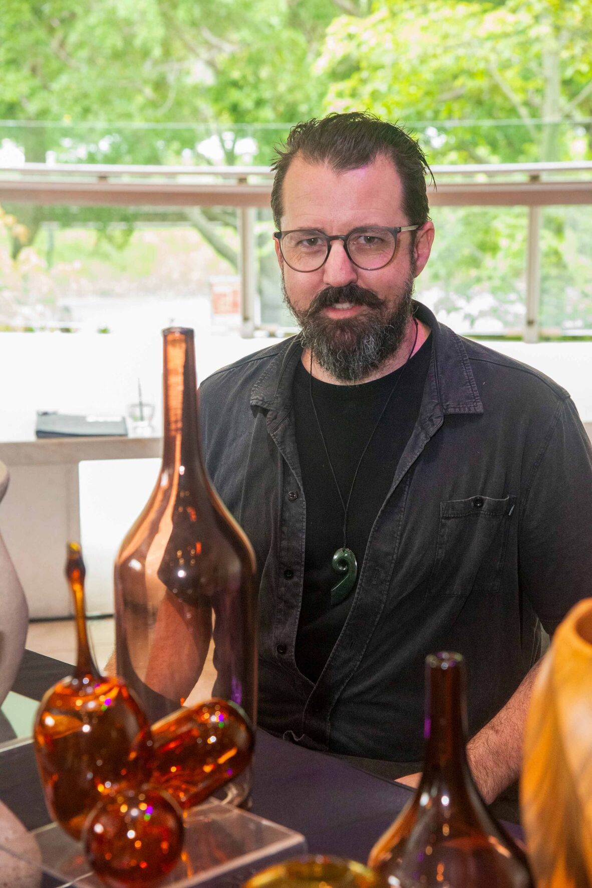 Man wearing black at table with glass designs