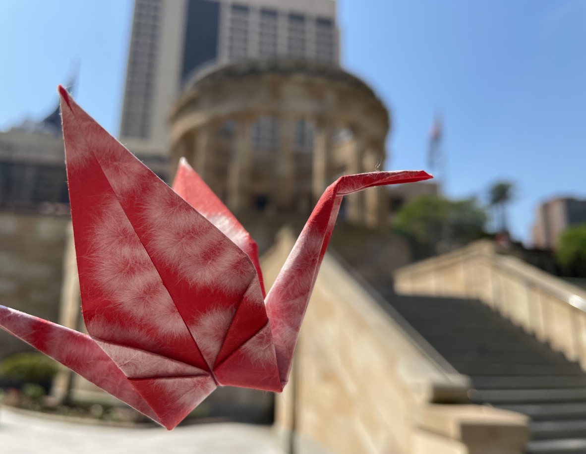 A paper crane in front of the Shrine of Remembrance