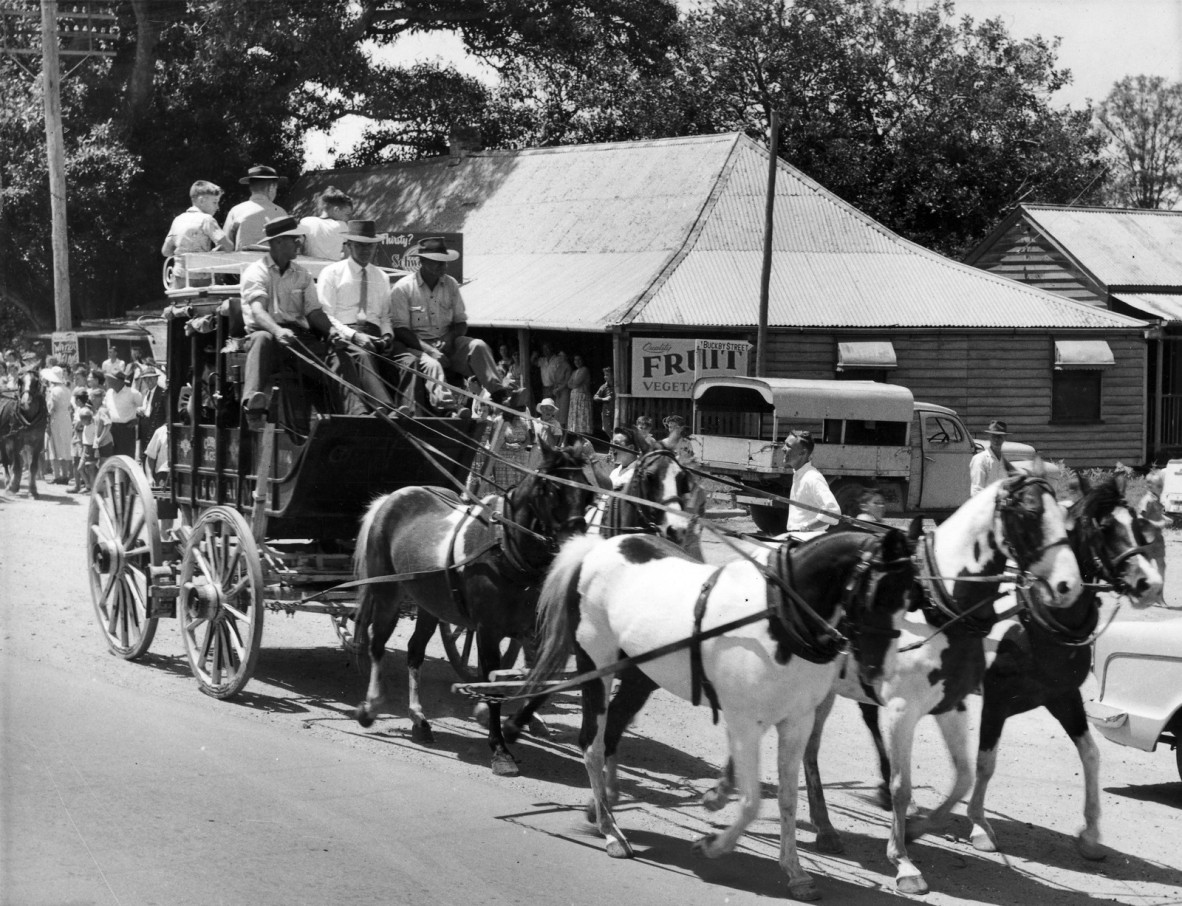 Replica Cobb & Co. coach with a load of passengers departing the original coaching station at Strathpine for Bald Hills, 7 November 1959