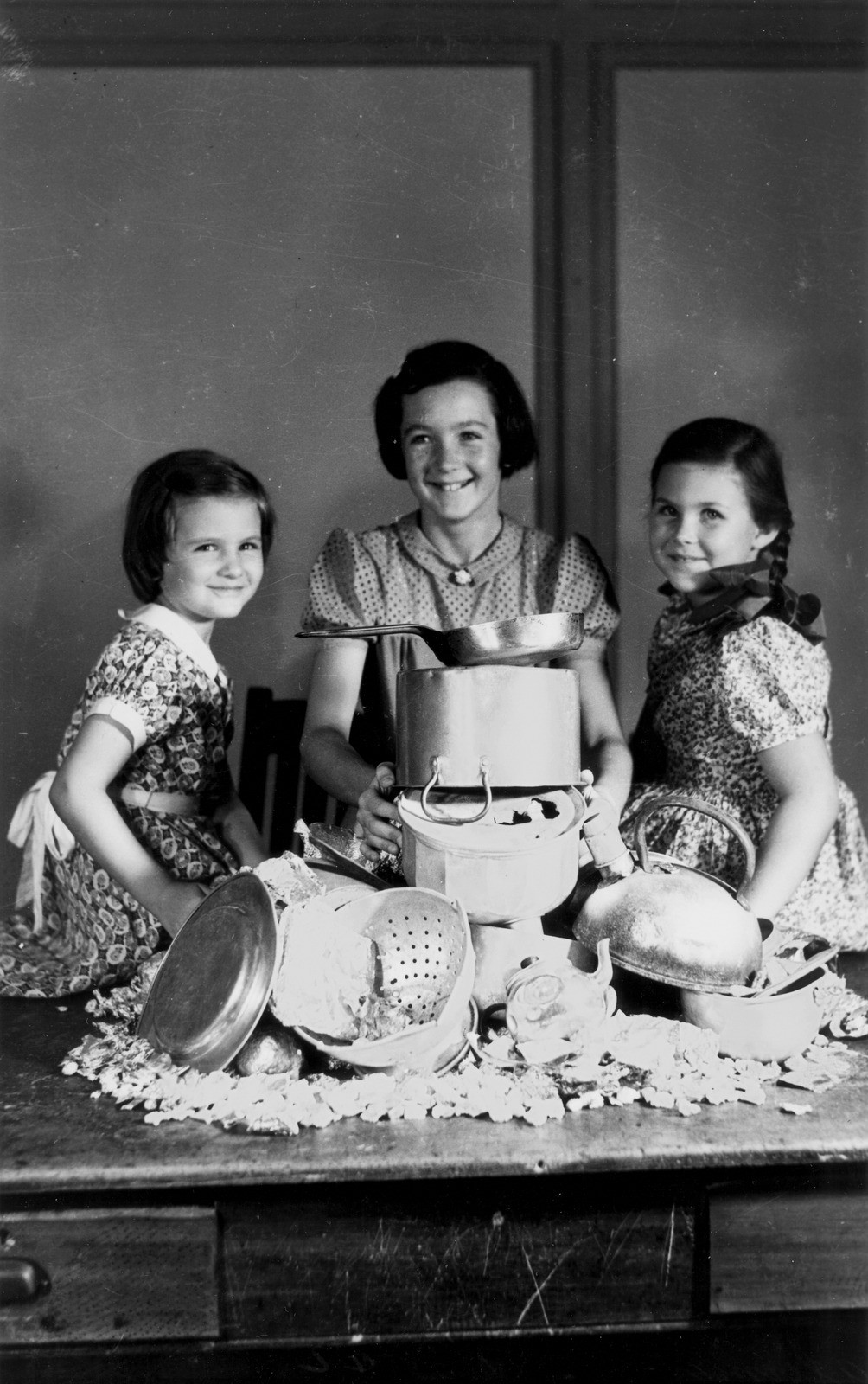 Three girls contributing to the war effort by collecting pots