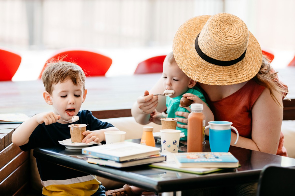 Woman with two young children with hot chocolates at the Library Cafe.